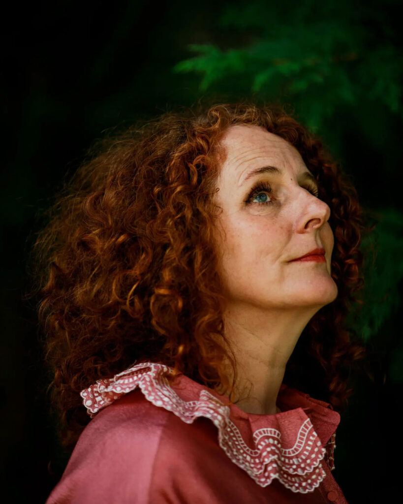 Yazar Maggie O'Farrell’in doğayla çevrili portresi, yukarı doğru bakan düşünceli bakışıyla.